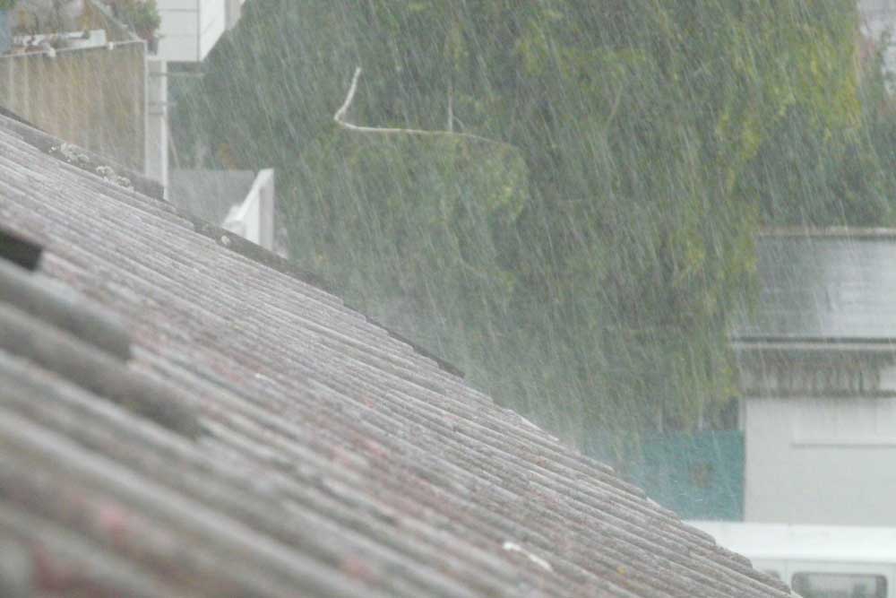 Korrect Roofing home roof exposed to heavy rainfall showing the importance of impact resistant roofing in Fort Worth.