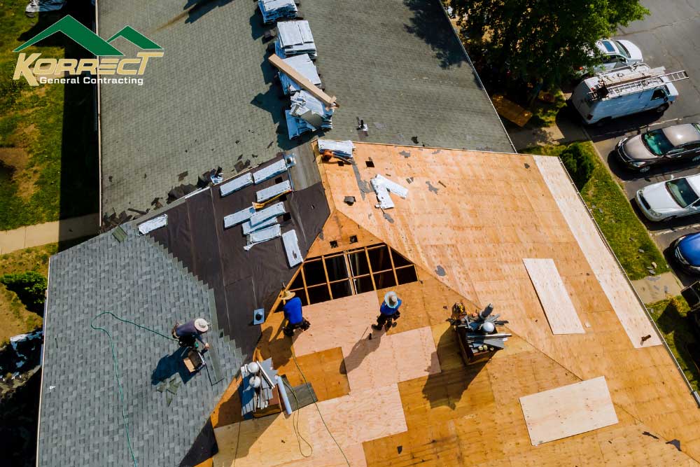 Drone view of roofing team repairing damaged shingles during inspection in Fort Worth with Korrect General Contracting.