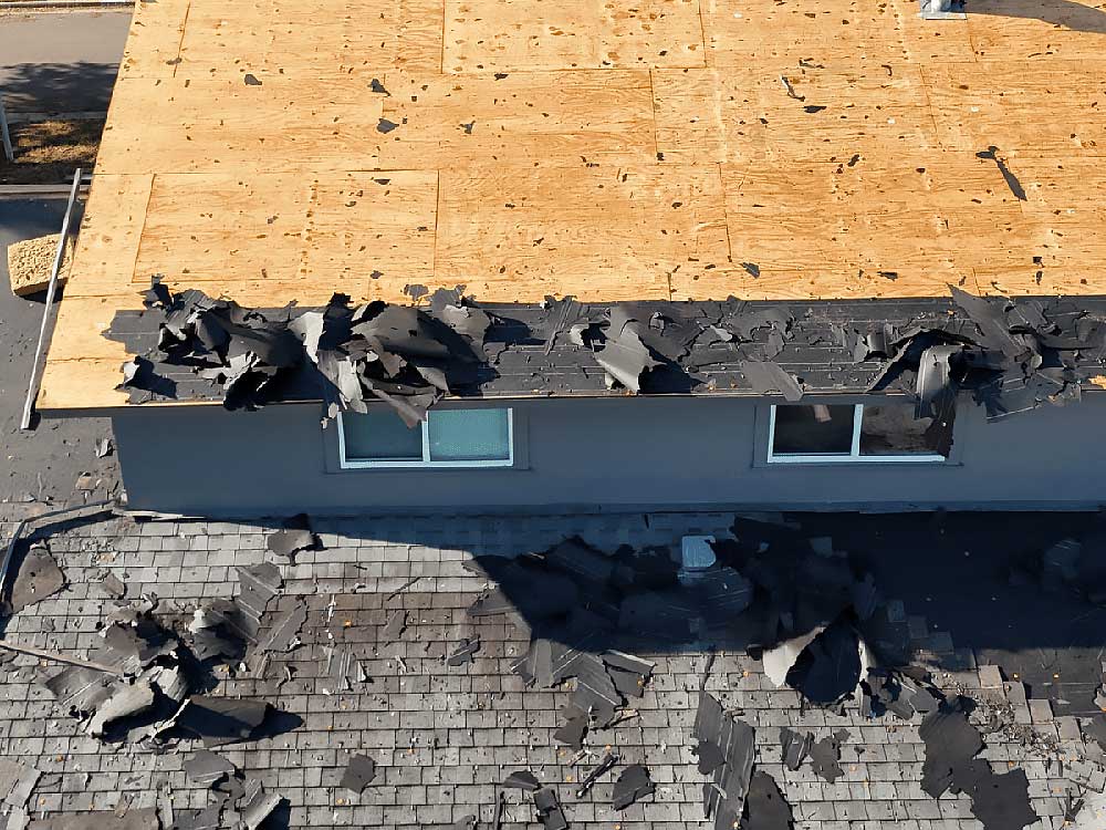 A roof undergoing replacement shows torn shingles and exposed wood decking, indicating significant repair work. This image highlights Fort Worth roofing services, emphasizing the need for professional roofing contractors in Dallas Fort Worth.| Korrect General Contracting Fort Worth TX